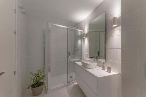 y baño blanco con lavabo y ducha. en Loft in the city, en Madrid
