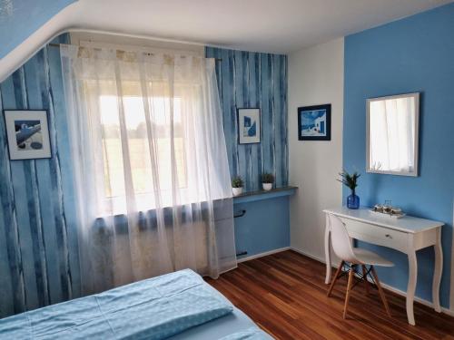 a bedroom with a bed and a desk and a window at Ferienwohnung Am Damm in Wesel