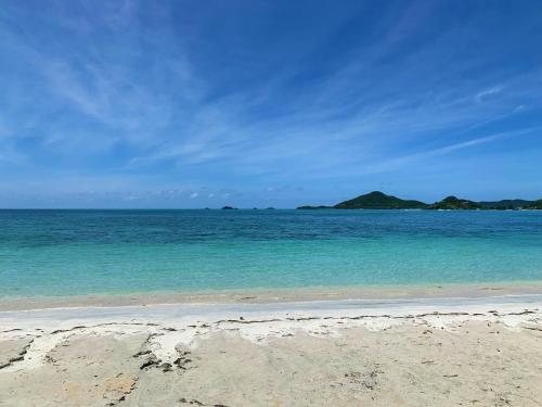 a beach with blue water and islands in the distance at Sugarfields Villa in Jolly Harbour