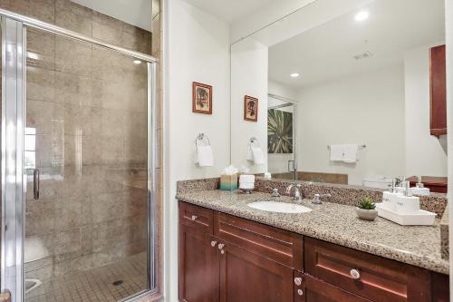 een badkamer met een glazen douche en een wastafel bij Luxurious Villa with Majestic Mountain View, 12 Pools, Spas, Ground Floor in La Quinta