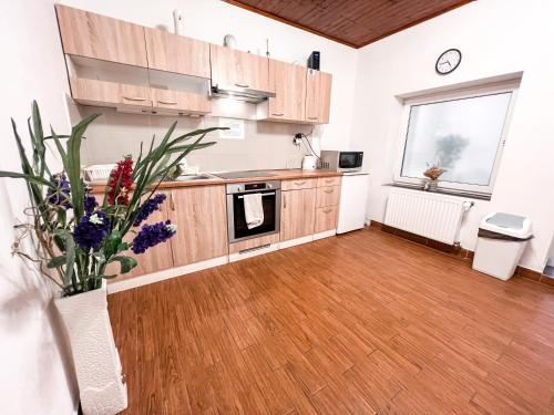 a kitchen with wooden cabinets and a vase of flowers at 3 Apartments in 1 location in Prague