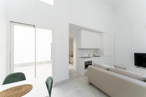 Sala de estar blanca con sofá y TV en Loft in the city, en Madrid