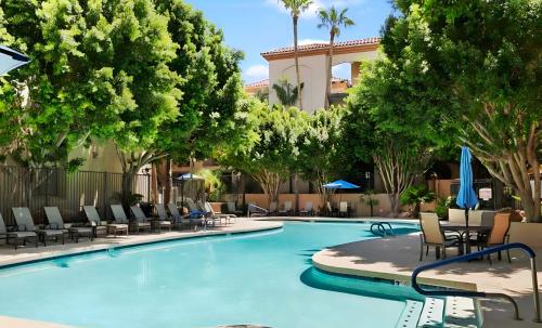 a large swimming pool with chairs and trees at Biltmore Bliss Desert Retreat! in Phoenix