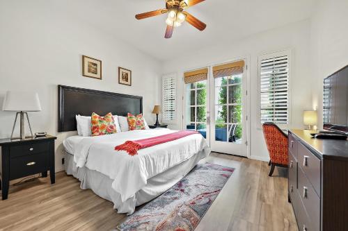 een slaapkamer met een bed en een plafondventilator bij Luxurious Villa with Majestic Mountain View, 12 Pools, Spas, Ground Floor in La Quinta