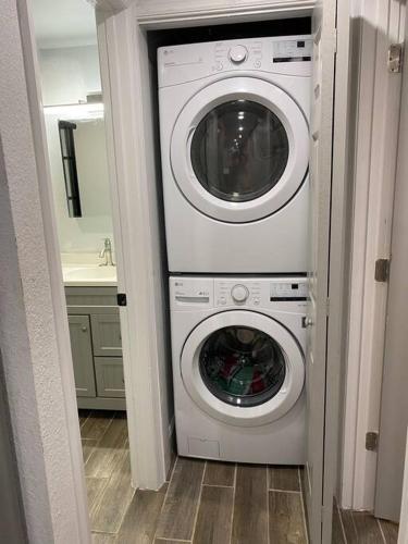 a washing machine and a washer and dryer in a bathroom at Betterplace 2-Bedooms Walk to Armature Works and Downtown Tampa in Tampa