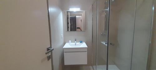 a bathroom with a sink and a shower at Sargaço Suíte Pool and Beach in Póvoa de Varzim