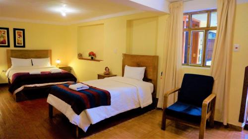 a hotel room with two beds and a chair at Eco Aventura Cusco in Cusco