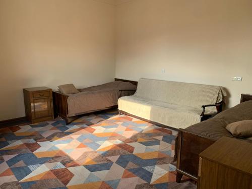 a room with two beds and a rug at DendroBak GuestHouse in Stepʼanavan