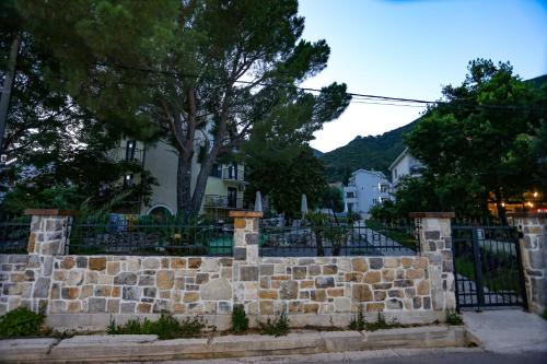 a stone fence in front of a building at Apartments Cukovic in Herceg-Novi