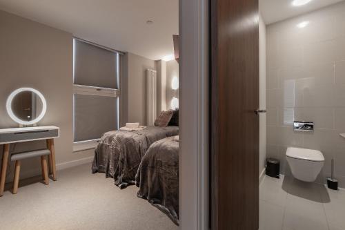 a bedroom with a bed and a sink and a toilet at MK CITY CENTRE, THE DIAMOND SUITE, FREE Parking Space, PREMIUM SPACIOUS Apartment with FOOSBALL TABLE in Milton Keynes