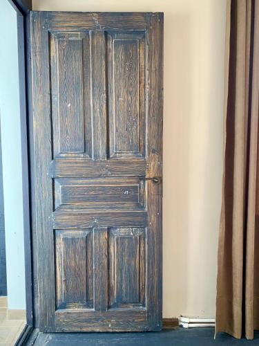 an old wooden door in the corner of a room at DendroBak GuestHouse in Stepʼanavan