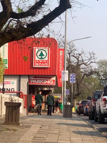 a fast food restaurant on a street with cars parked at The Lazy Expat in Paarl
