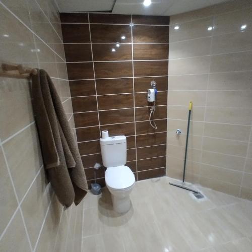 a bathroom with a toilet and towels on a wall at Florenza Khamsin 83 quarterm. Arpartment in Hurghada