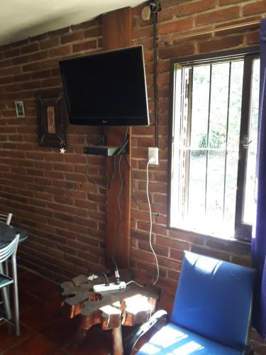 sala de estar con TV en una pared de ladrillo en Ojos de cielo en Bialet Massé