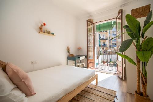 1 dormitorio con cama blanca y balcón en 12PAR1003 - Luminoso piso en Paralelo, en Barcelona