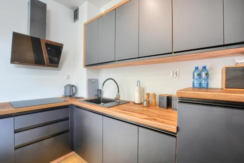 a kitchen with gray cabinets and a wooden counter top at Wilcze Zacisze in Ustrzyki Dolne
