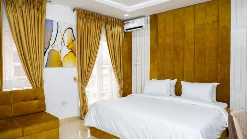ein Schlafzimmer mit einem großen Bett und einem Stuhl in der Unterkunft Delight Apartments - Oniru VI in Lagos