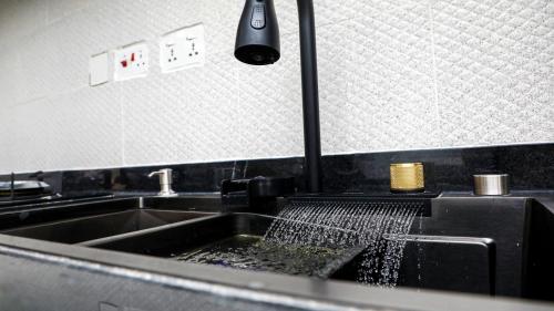 a kitchen with a sink with a strainer in it at Delight Apartments - Oniru VI in Lagos