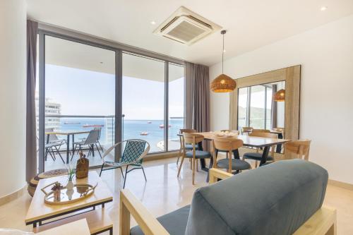 a living room with a table and chairs and the ocean at Grand Marina Suites Santa Marta in Santa Marta