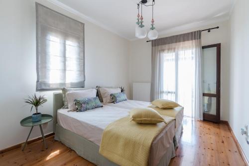 a bedroom with two beds and a window at Villa Sarri by Sarris Winery in Metaxáta