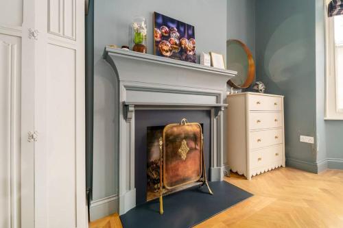 a living room with a fireplace with a chair at Cozy 2 Bedroom garden flat in London