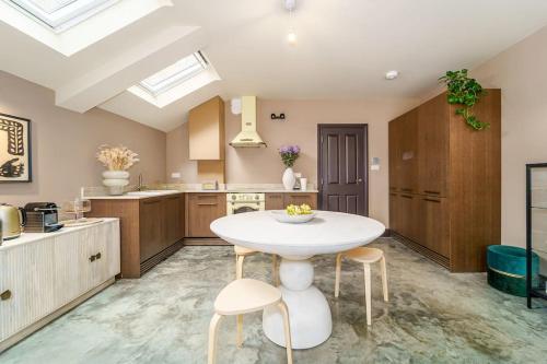 a kitchen with a white table and stools at Cozy 2 Bedroom garden flat in London