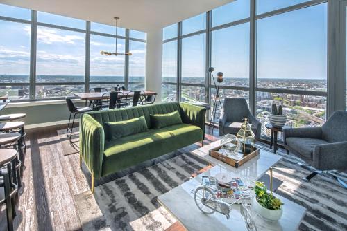 a living room with a green couch and a table at Penthouses near Fulton Market-Cloud9-365 in Chicago