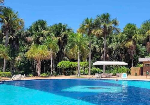 una piscina con palmeras al fondo en Flat Gran Lençóis, en Barreirinhas