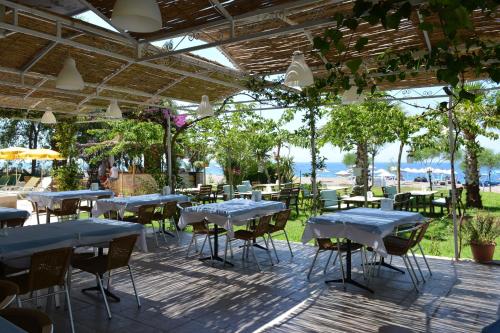 un grupo de mesas y sillas en un patio en Palmiye Hotel, en Özdere