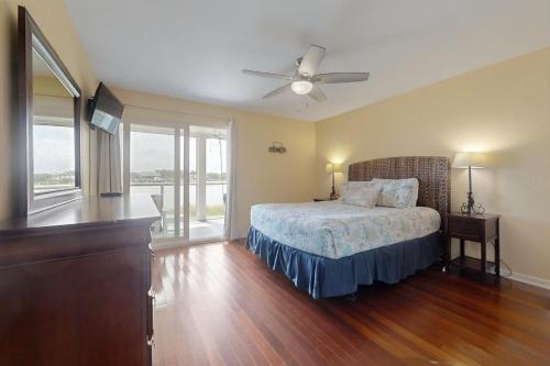 a bedroom with a bed and a ceiling fan at Mariners Cay 40 in Folly Beach