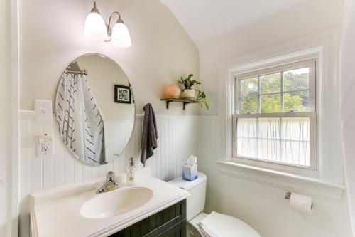 Baño blanco con lavabo y espejo en Chic Front Royal Retreat Near Shenandoah River! en Front Royal