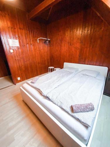 a bed in a room with a wooden wall at 3 Apartments in 1 location in Prague