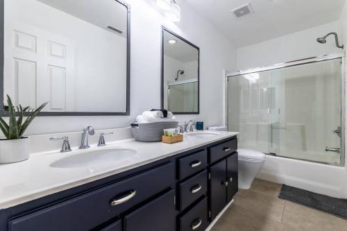 a bathroom with a sink and a toilet and a mirror at The Nest at Woodside: Lux LA getaway + office/spa in Santa Clarita