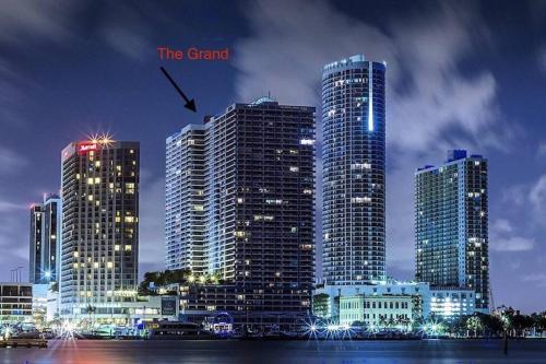 a group of tall buildings in a city at night at Cloud Nine! Direct Water Views of Bay & Ocean! in Miami