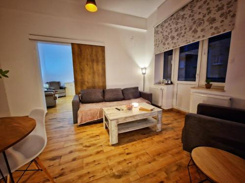 - un salon avec un canapé et une table dans l'établissement APARTAMENT BÉATRICE, à Przemyśl
