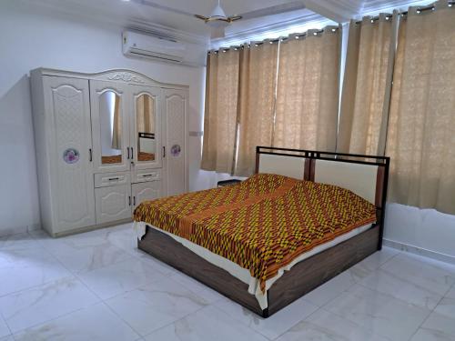a bedroom with a bed and a dresser at Pool House Retreat in Accra in Accra