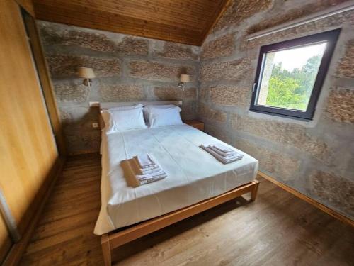 a small bedroom with a bed in a brick wall at Quinta de Casal do Bairro - Casa do Alpendre in Guimarães