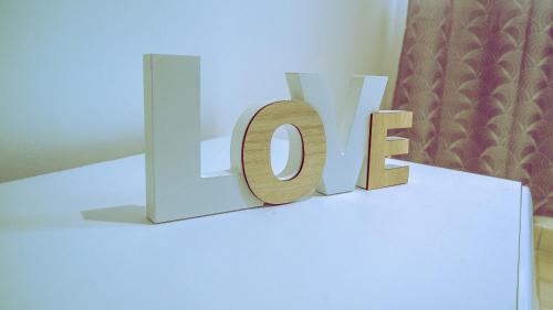 a white table with a sign that says love on it at Pool House Retreat in Accra in Accra
