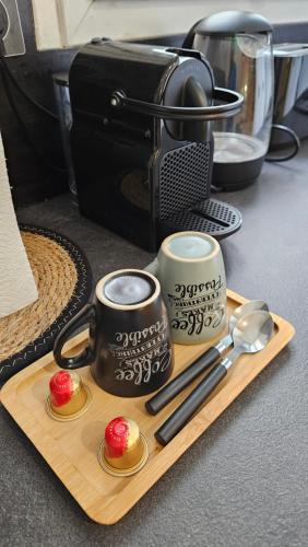 - un plateau avec deux tasses à café et une caméra dans l'établissement Parisian Cocoon - PARIS ORLY, à Choisy-le-Roi