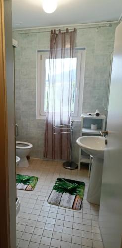 a bathroom with a sink and a toilet and a window at Tenuta PARAVANO in Povoletto
