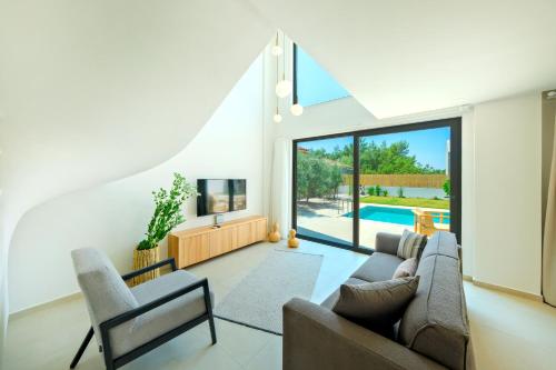 a living room with a couch and chairs and a pool at Villa Neo with 2 private pools, bbq, jacuzzi and sauna in Fethiye