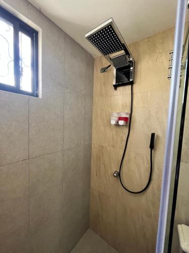La salle de bains est pourvue d'une douche avec un pommeau de douche. dans l'établissement Suite Los Sauces, à Ibarra