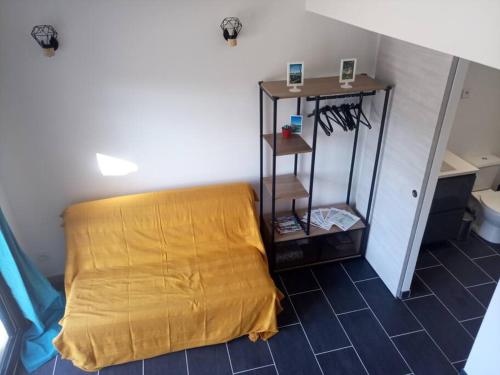 a room with a bed with a yellow sheet on it at Petite maison avec jardin entre lac et village in Hourtin
