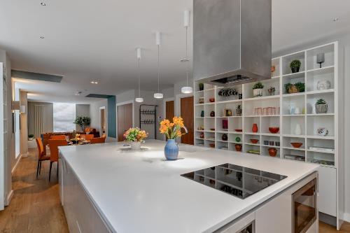 a kitchen with a white counter and a dining room at MK CITY CENTRE, THE DIAMOND SUITE, FREE Parking Space, PREMIUM SPACIOUS Apartment with FOOSBALL TABLE in Milton Keynes