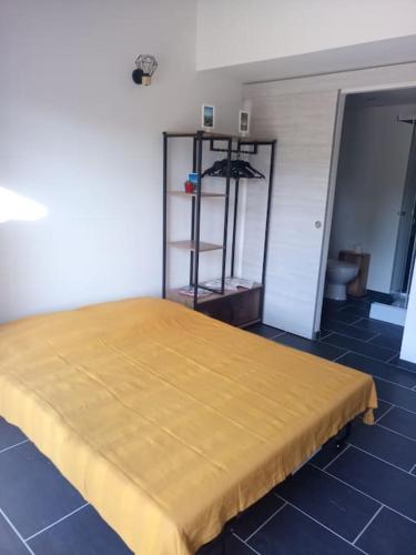 - une chambre avec un lit doté d'un couvre-lit jaune dans l'établissement Petite maison avec jardin entre lac et village, à Hourtin