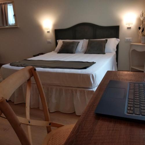 a bedroom with a bed and a laptop on a table at Relais Ca' Morenica in Valeggio sul Mincio