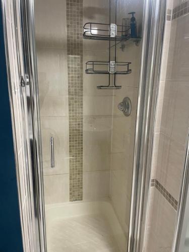 La salle de bains est pourvue d'une douche avec une porte en verre. dans l'établissement Home away from Home, à Cross Gates