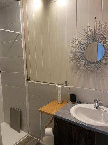 a bathroom with a sink and a mirror at Gîte Lauraët in Linxe