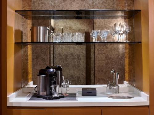 a counter with a coffee maker and glasses on a shelf at Hotel Ziggy Los Angeles in Los Angeles
