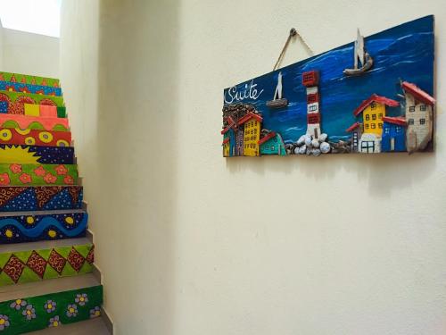 a painting of a lighthouse on a wall next to stairs at Casa Djarmai Boutique Apartments in Vila do Porto